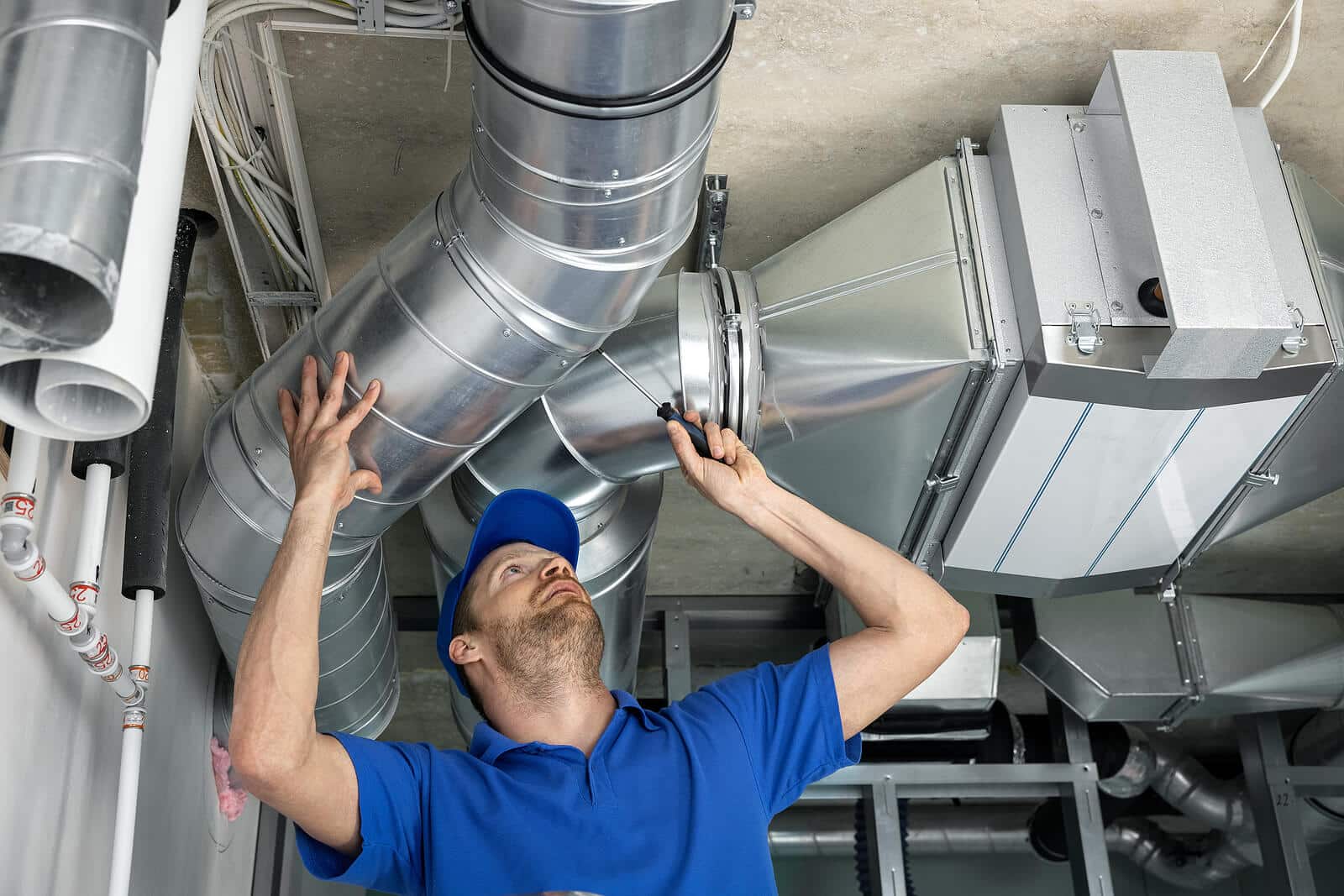 HVAC technician inspecting and repairing air ducts in San Dimas