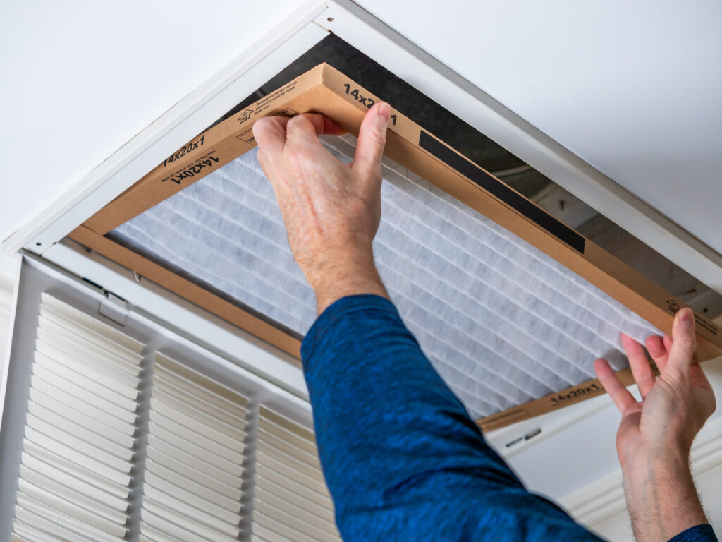 HVAC technician replacing a home air filter in San Dimas