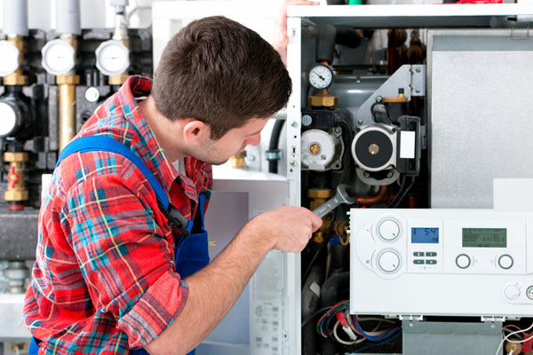 Heating technician repairing boiler controls in San Dimas