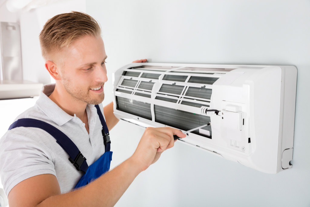 HVAC technician maintaining a ductless air conditioner in San Dimas