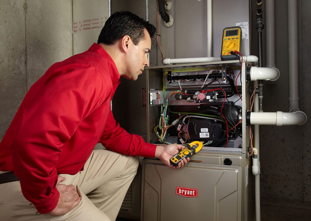 Heating technician diagnosing a furnace repair in San Dimas