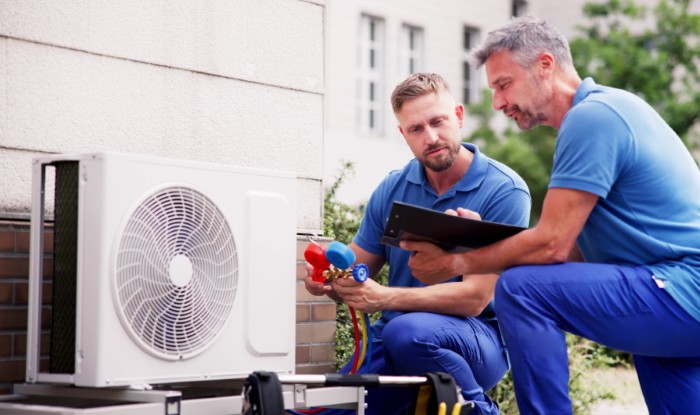HVAC technicians installing an outdoor air conditioning unit in San Dimas